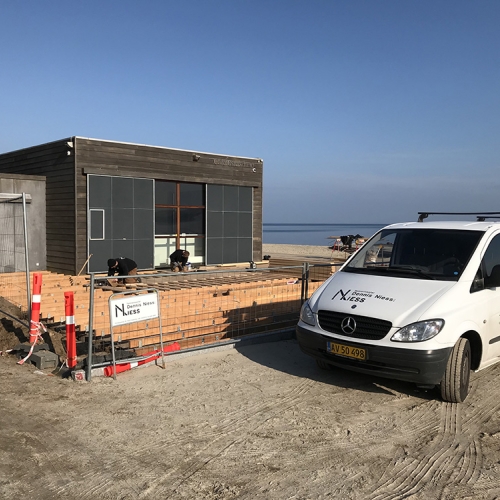 Tømrer bygger ny træterrasse på stranden i Fredericia